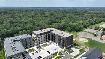 an aerial view of three apartment buildings and a parking lot